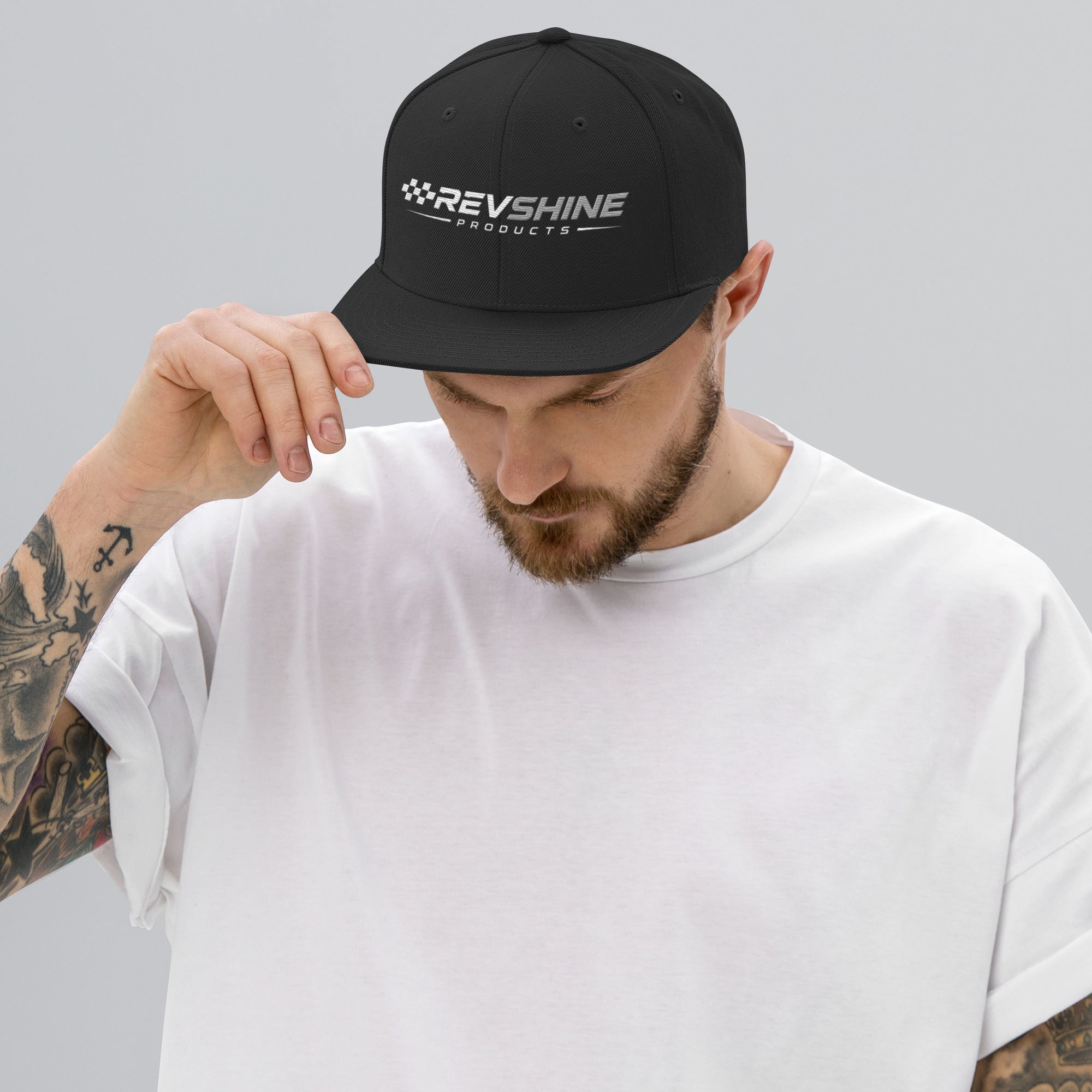 Black RevShine Logo Snapback Hat with front logo embroidery, classic adjustable baseball cap style.